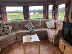 a living room with a couch and a coffee table at Màire’s Mobile Home in Falcarragh