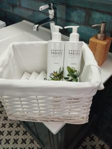 a white basket sitting on a bathroom sink at Georgia's Sweet Home in Nafplio