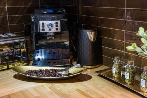 - un comptoir avec une cafetière et une assiette de grains de café dans l'établissement Lux Versace Pad Sleeps 10 Hot Tub, Cinema & Games Room, à Londres