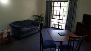 a living room with a couch and a table at Shakespeare Motel in Mackay
