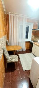 Pokój ze stołem, krzesłem i oknem w obiekcie Квартира по вул Липківського 43 w Kijowie