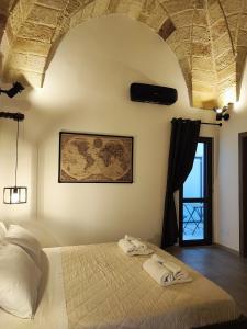 Loft Porta Sud Civ.33 في برينديسي: غرفة نوم عليها سرير وفوط