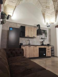 Loft Porta Sud Civ.33 في برينديسي: غرفة معيشة مع أريكة أمام مطبخ