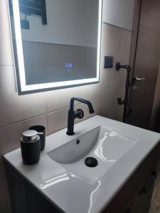 布林迪西的住宿－Loft Porta Sud Civ.33，浴室水槽设有水龙头和镜子