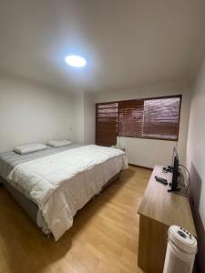 - une chambre avec un lit et un bureau avec un ordinateur dans l'établissement Departamento La Molina, à La Molina