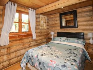 a bedroom with a bed in a log cabin at Brynallt Country Park in Ellesmere