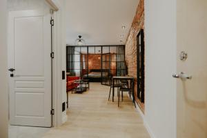 um corredor com uma sala de jantar e uma parede de tijolos em Old brick boutique apartments em Klaipėda