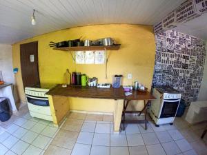 uma cozinha com uma mesa de madeira e um fogão em Namastê Pousada e Camping em Cananeia
