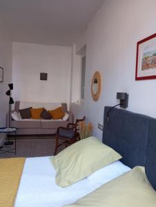 ein Wohnzimmer mit einem Bett und einem Sofa in der Unterkunft Chambre d'hôtes PMR Hildegarde in Moissac