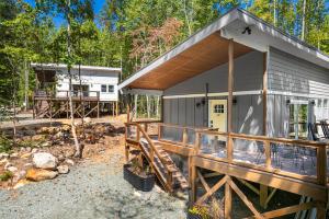 a home with a porch and a deck with a house at NEW Beehive Tree House Retreat in Pittsboro