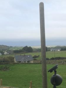 a view of a field with a house and a pole at Màire’s Mobile Home in Falcarragh