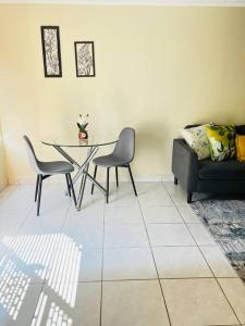 sala de estar con mesa, sillas y sofá en Luba Suite en Durban