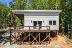 una casetta con un ponte nel bosco di New H2O Oasis Tree House a Pittsboro