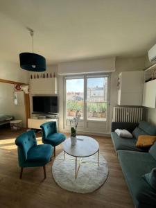 a living room with a couch and two chairs and a table at Appartement cosy orangerie in Strasbourg
