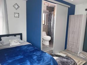 a bedroom with a bed and a bathroom with a toilet at Jardines Ambato in Ambato