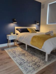 um quarto com uma cama grande e uma parede azul em The Sydenham Snug em Forest Hill