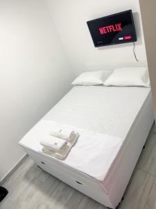 a white bed in a room with a sign on it at Hotel Aeroporto Congonhas 4 in Sao Paulo