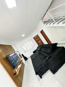 a bedroom with a black bed and a laptop on the floor at Hotel Aeroporto Congonhas 4 in Sao Paulo