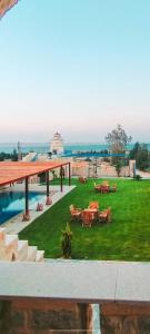 a resort with a lawn with tables and a pool at Al Burj Hotel in Tunis