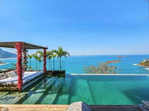 a swimming pool with a view of the ocean at Linda casa no Joá, com vista incrível do mar do Rio in Rio de Janeiro