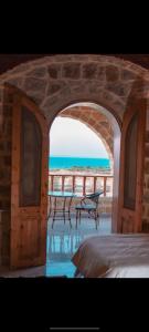 a stone archway with two benches in front of the beach at Al Burj Hotel in Tunis