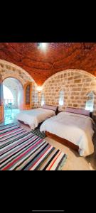 a bedroom with two beds and a stone wall at Al Burj Hotel in Tunis