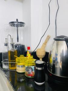 uma bancada de cozinha com frascos e um liquidificador em Emerald BnB em Ruaka