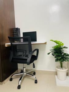 a black office chair sitting in front of a desk at Emerald BnB in Ruaka
