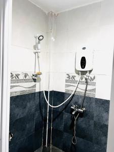 um chuveiro na casa de banho com uma cabeça de chuveiro em Emerald BnB em Ruaka