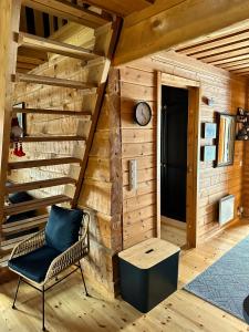 um quarto com uma escada de madeira e uma cadeira em Holiday Home Ruka Lammensyli em Ruka