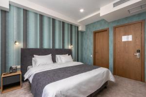 ein Schlafzimmer mit einem großen Bett und einer Holztür in der Unterkunft Brooch Boutique Hotel in Tbilisi City