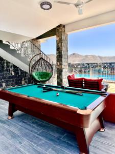 a pool table in a living room with a view at JA view chalet in Duwaykhīlah