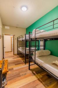 a room with three bunk beds and a green wall at Pintler's Portal Hostel in Anaconda