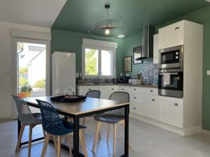 a kitchen with a wooden table and chairs in it at * Domaine de la Solaie * - Proche Bords de Loire in Saint-Denis-de lʼHôtel
