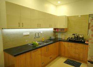 a kitchen with wooden cabinets and a sink at Luxury Homes - Cochin Airport - Nedumbassery in Angamaly