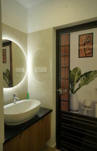 a bathroom with a sink and a mirror at Luxury Homes - Cochin Airport - Nedumbassery in Angamaly