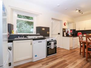 a kitchen with white appliances and a dining room at North Lodge in Forfar