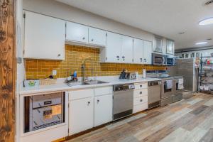 uma cozinha com armários brancos e electrodomésticos de aço inoxidável em Pintler's Portal Hostel em Anaconda