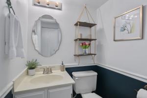 a bathroom with a sink and a toilet and a mirror at Luxury Sterling townhome - Private, Self checkin in Sterling +24 photos