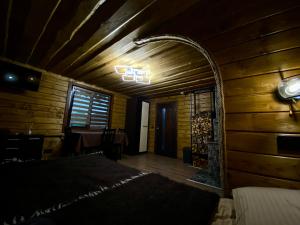 - une chambre avec un lit dans une pièce en bois dans l'établissement LINDEN GROVE, à Vygoda
