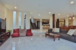 a large living room with couches and a tv at The Arnaya in Kuta