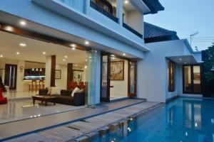 a house with a swimming pool next to a house at The Arnaya in Kuta