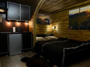 um quarto com uma cama num chalé de madeira em LINDEN GROVE em Vygoda