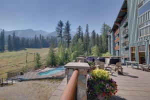 a balcony of a hotel with a pool and tables and chairs at Snow Creek Lodge by FantasticStay in Fernie
