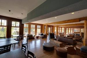 a large living room with couches and tables and windows at Snow Creek Lodge by FantasticStay in Fernie