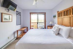 Un dormitorio con una gran cama blanca y una ventana en Snow Creek Lodge by FantasticStay, en Fernie