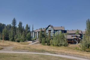 a large building in the middle of a field at Snow Creek Lodge by StayIn in Fernie