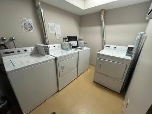 a laundry room with three washing machines at Snow Creek Lodge by FantasticStay in Fernie