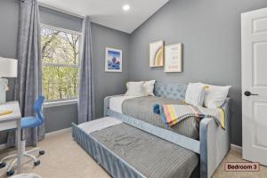 a bedroom with a bed and a desk and a window at Cozy 4BR Townhome, Family Community, 40 Mins to DC in Sterling