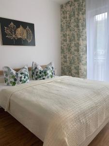ein Schlafzimmer mit einem großen Bett mit Kissen und einem Fenster in der Unterkunft Ferienwohnung „Mehr vom Meer“ in Sassnitz